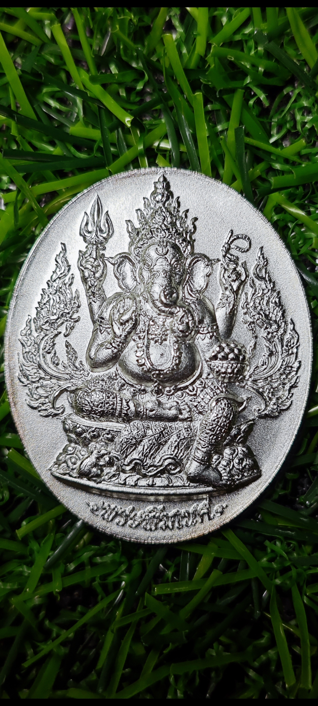 เหรียญพระพิฆเนศ รุ่นปฐมฤกษ์ สร้างโรงพยาบาลวัดสมานรัตนาราม จ.ฉะเชิงเทรา ปี 2556 ขนาดเหรียญ สูง 3.5 ซม. กว้าง 2.7 ซม.