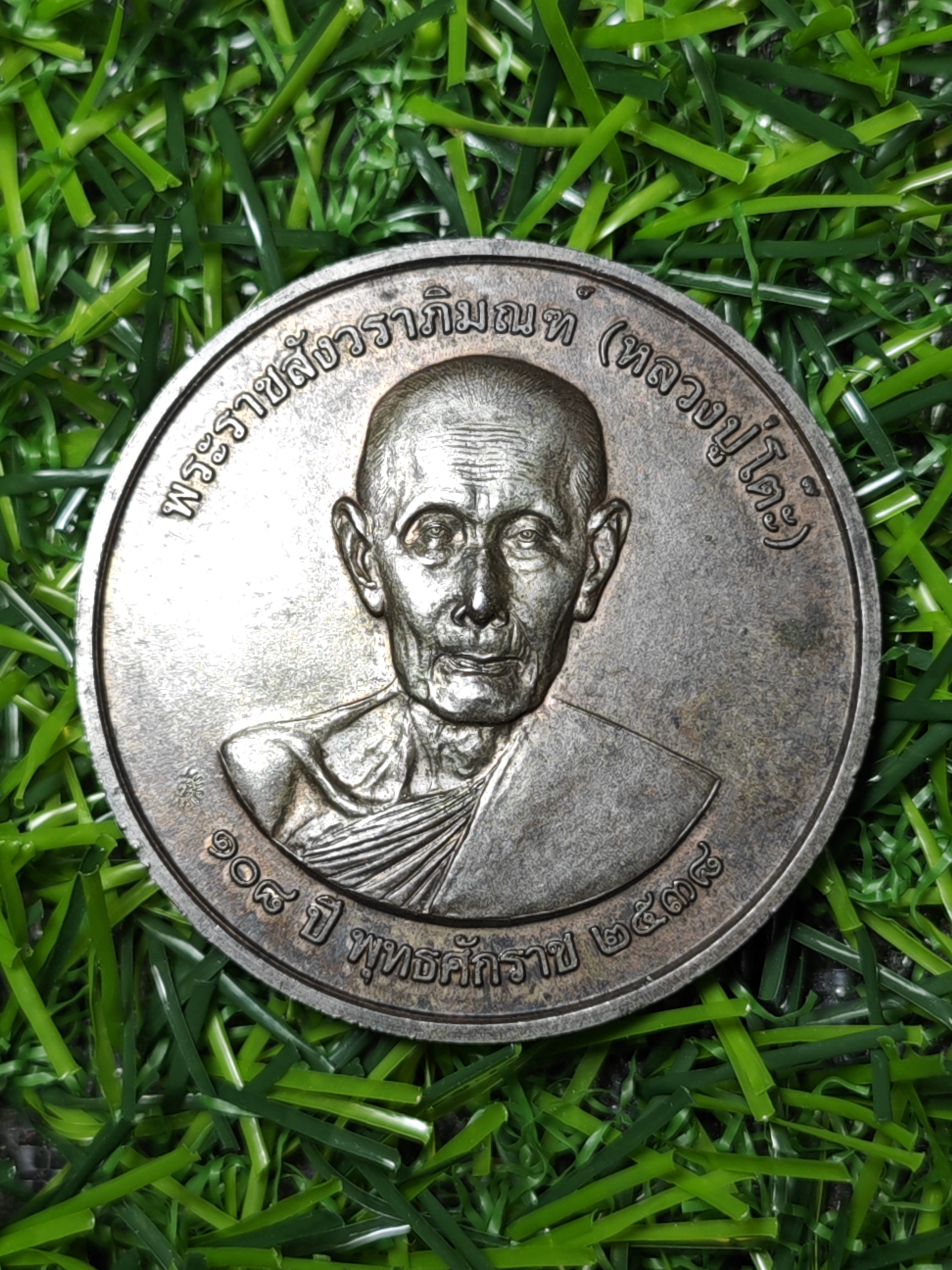 เหรียญหลวงปู่โต๊ะ อินฺทสุวัณฺโณ รุ่น เจริญพรล่าง วัดถ้ำสิงโตทอง ราชบุรี บล็อคเสมา ชุบเงิน พื้นแดง ขอบน้ำเงิน สร้าง 69 เหรียญ ปี 2565